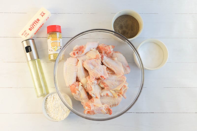 All ingredients for Lemon Pepper Wings in a glass bowl.