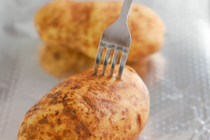 placing fork in potato