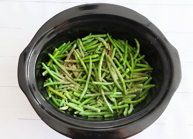 adding seasoning to the green beans