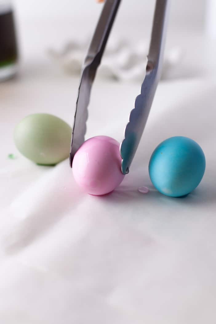 placing dyed eggs on a towel to dry.