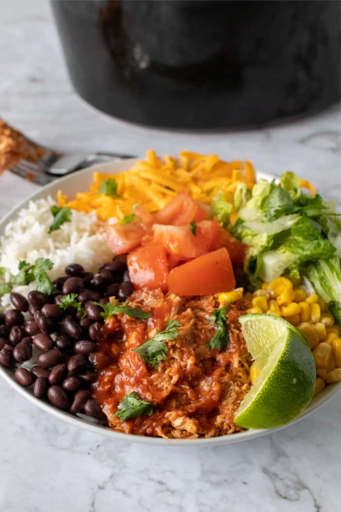 Slow Cooker Shredded Mexican Chicken in a bowl with lime