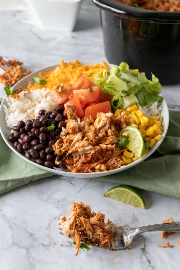 Slow Cooker Shredded Mexican Chicken topped with all the ingredients