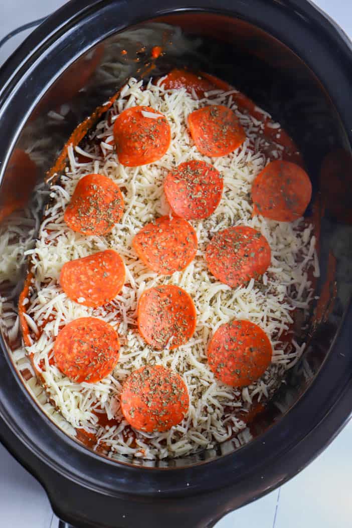 adding cheese and pepperoni to the casserole