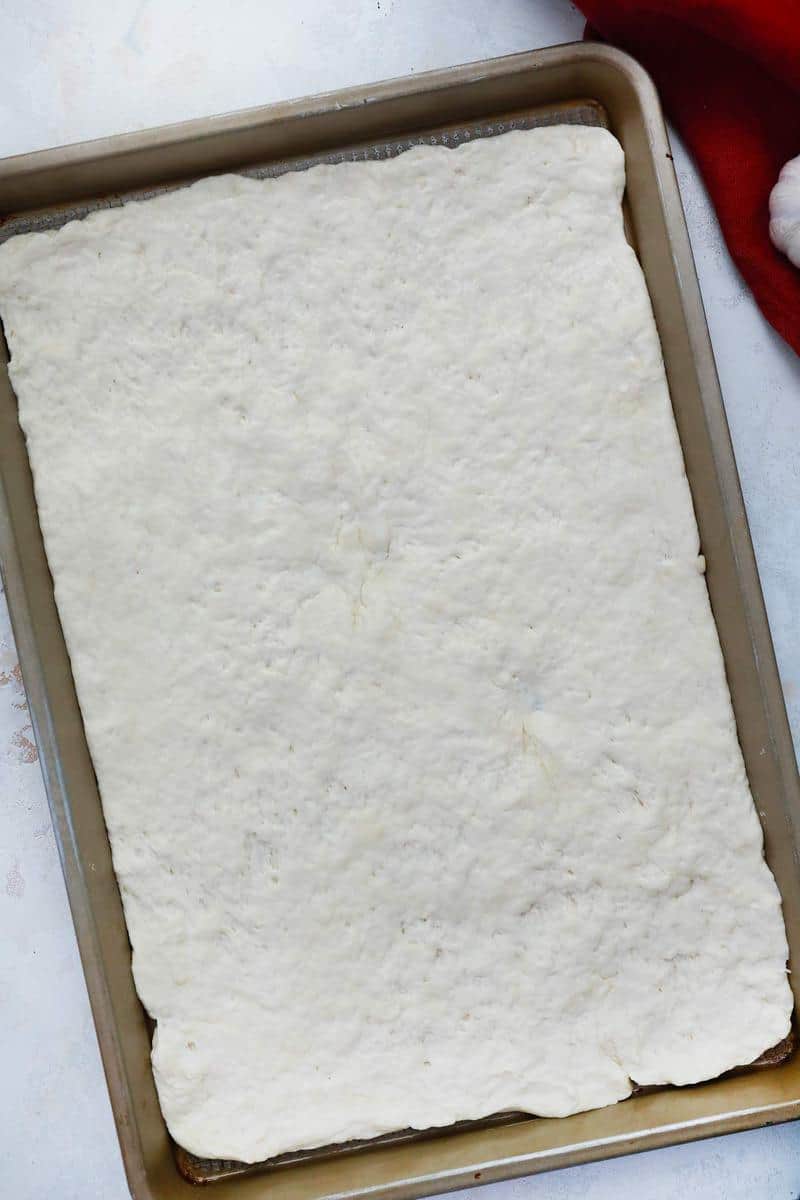 dough rolled out on a baking sheet