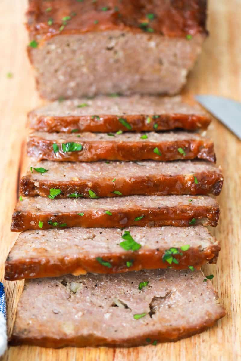 closeup of meatloaf sliced on wooden cutting board