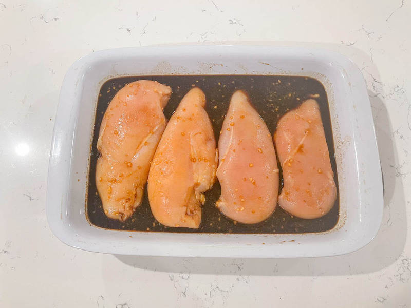 chicken breasts in baking pan with teriyaki sauce