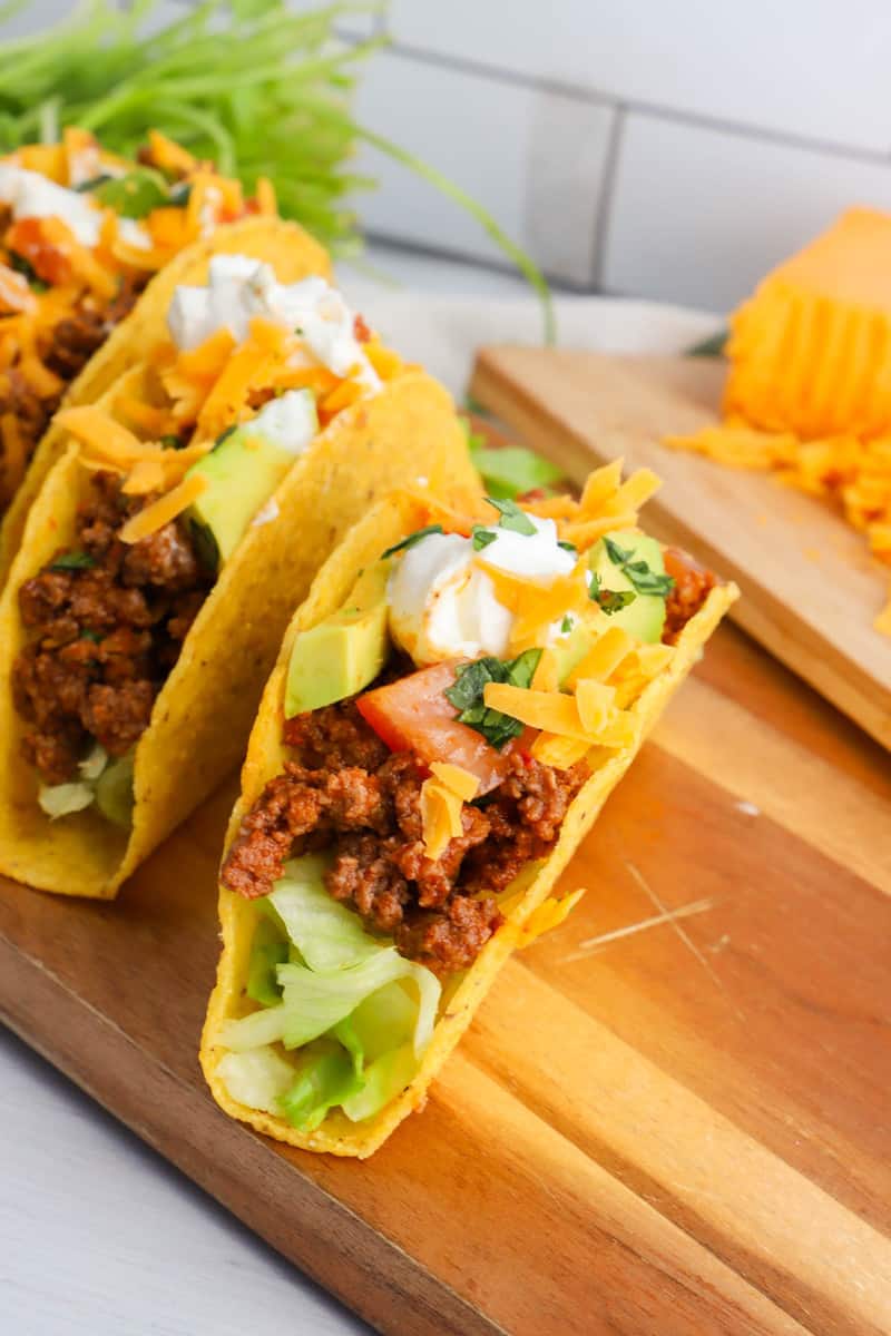 finished tacos on wooden serving board