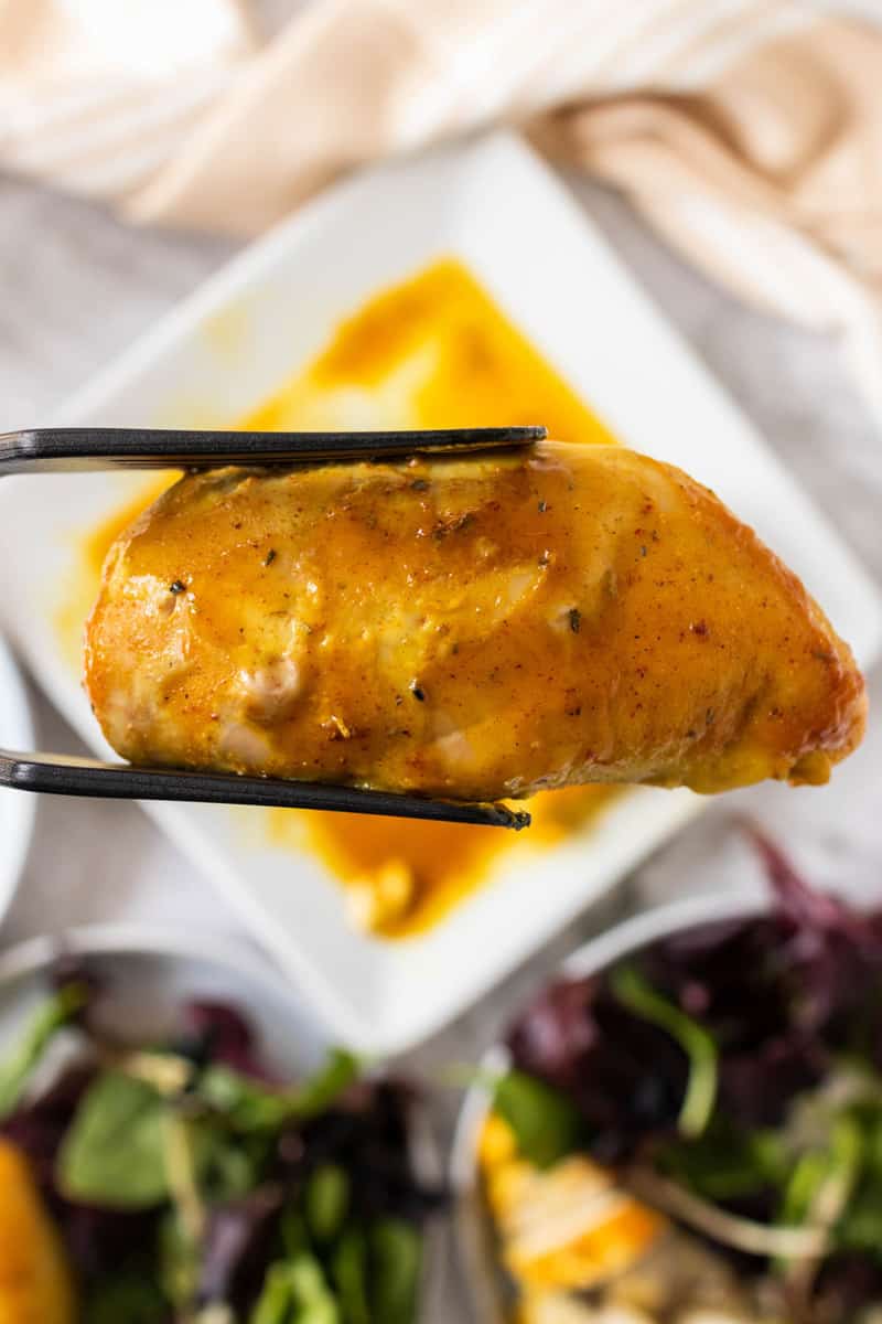 holding Honey Mustard Chicken with tongs