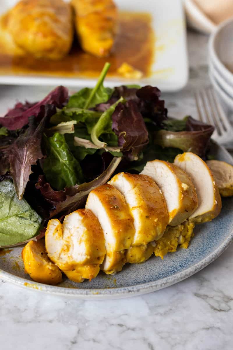 Honey Mustard Chicken sliced on a plate with salad