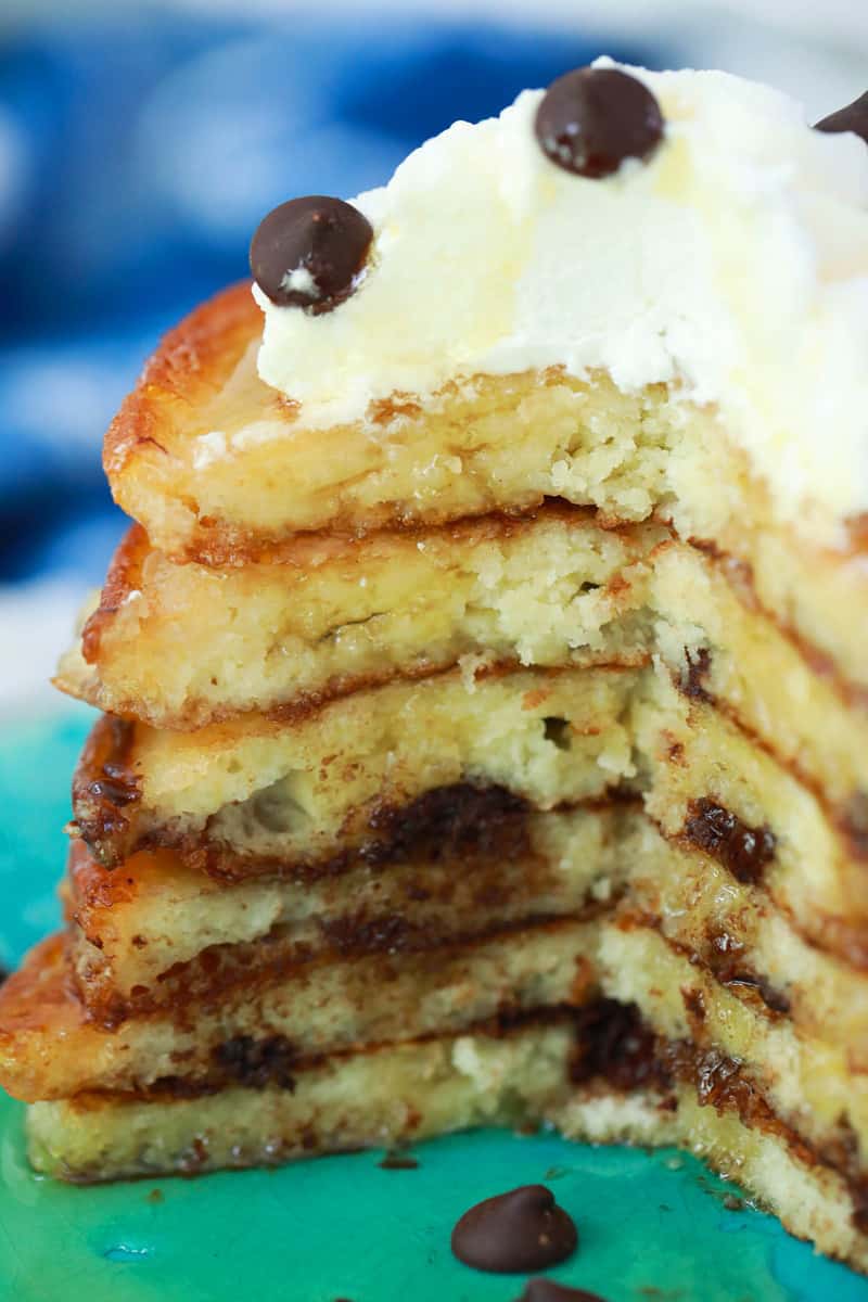 closeup shot of pancakes topped with whipped cream and chocolate chips