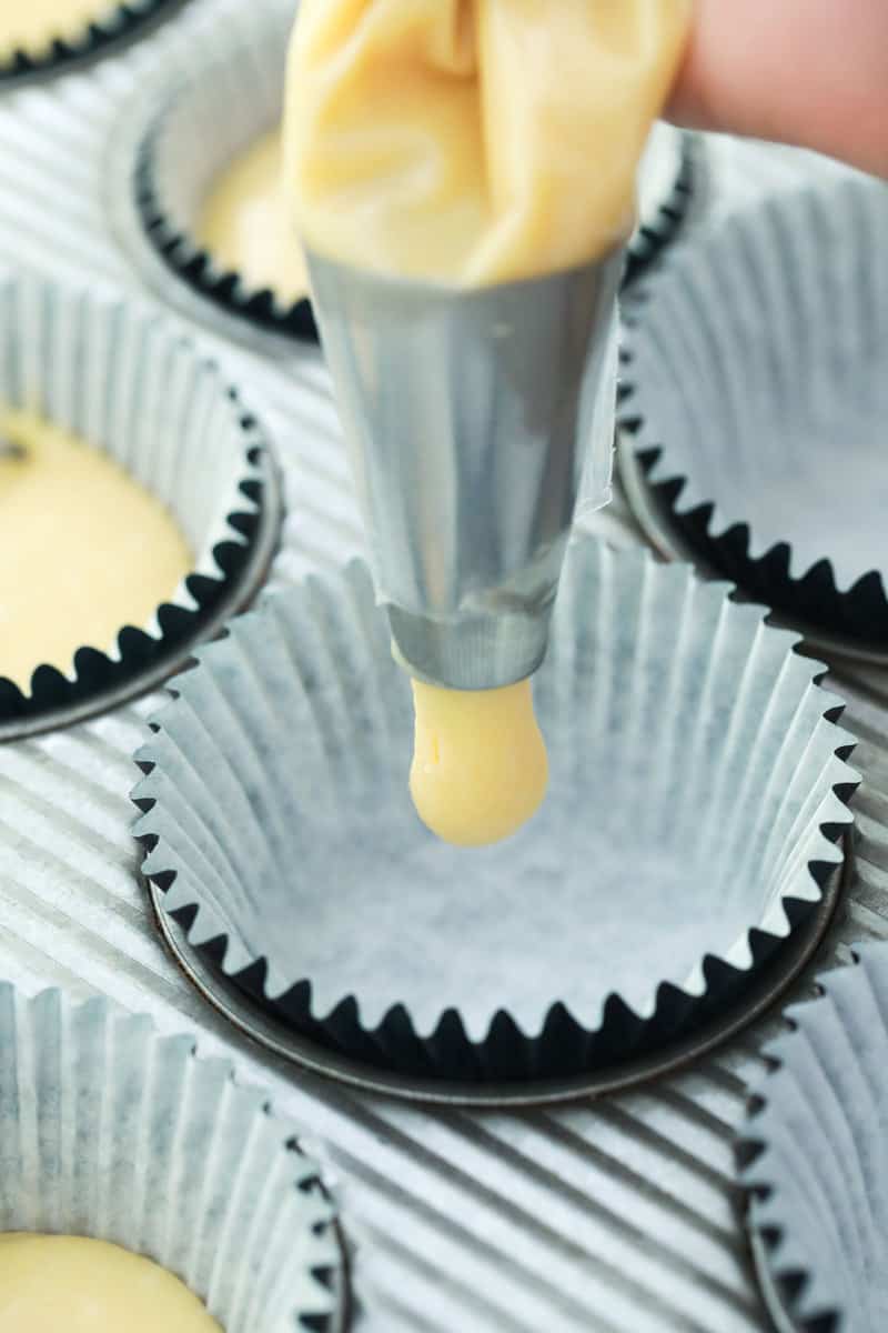 using piping bag to fill cupcake liners in cupcake pan