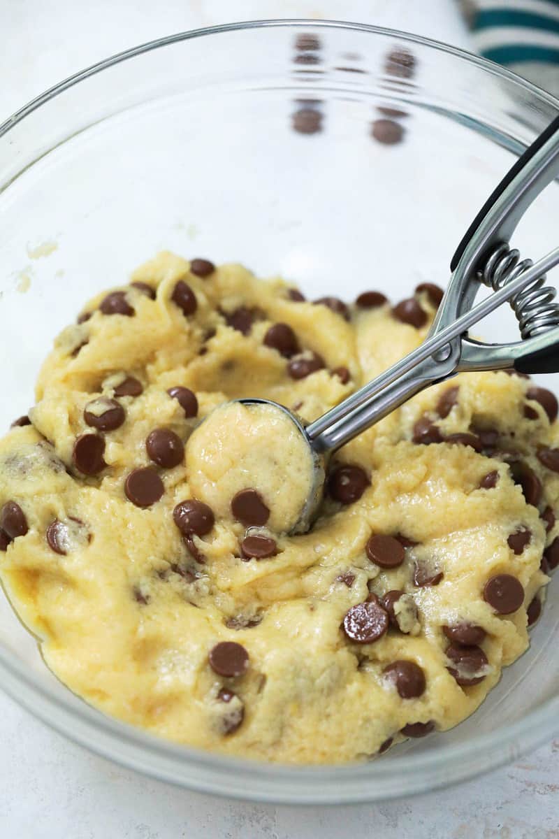 scooping the dough out of bowl with a cookie scoop