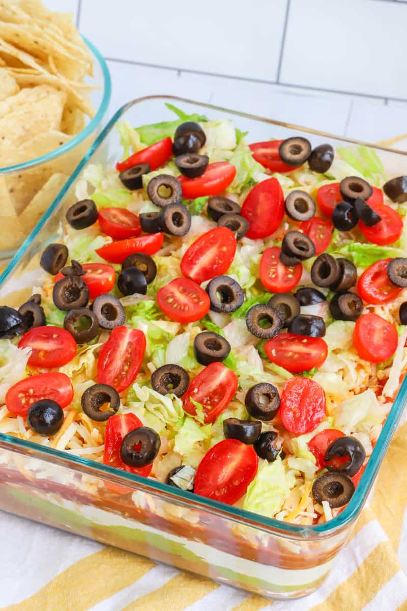 Top down photo of 7 layer dip on a yellow and white striped towel