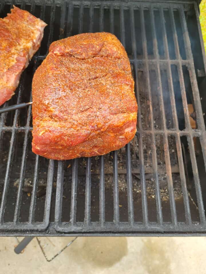 rubbed pork butt on smoker close to heat source