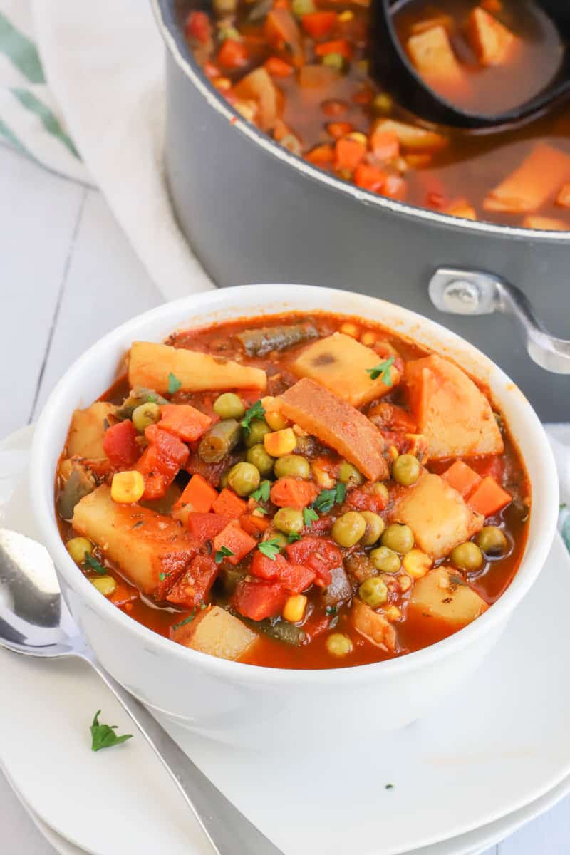 closeup photo of vegetable soup in white bowl on white plate