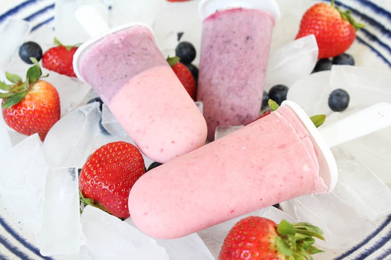 yogurt popsicles closeup on plate of ice with strawberries.