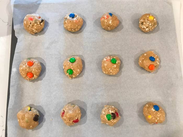 oatmeal M&M cookies on baking sheet with parchment paper