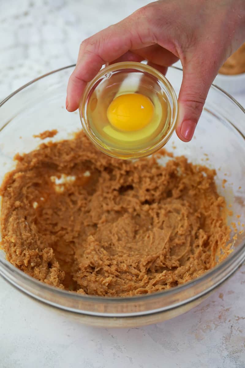 adding egg to sugar butter and peanut butter mix