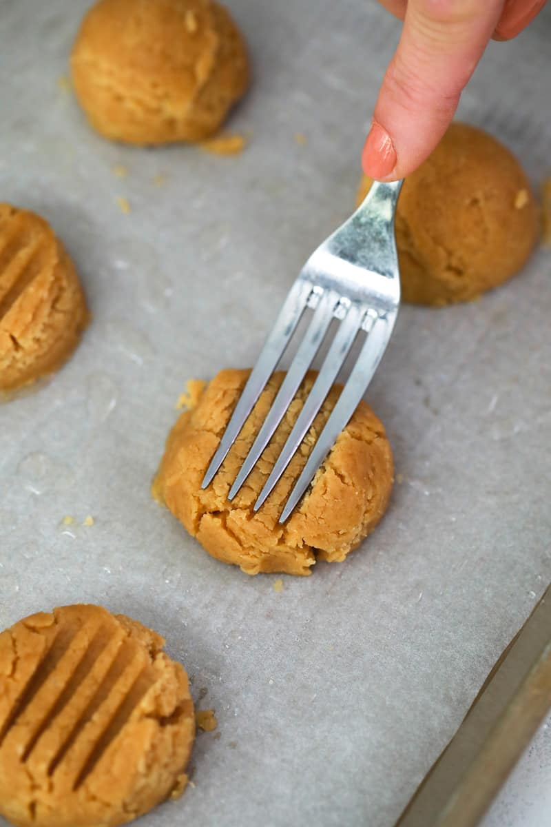 using a fork to press and mark the cookies