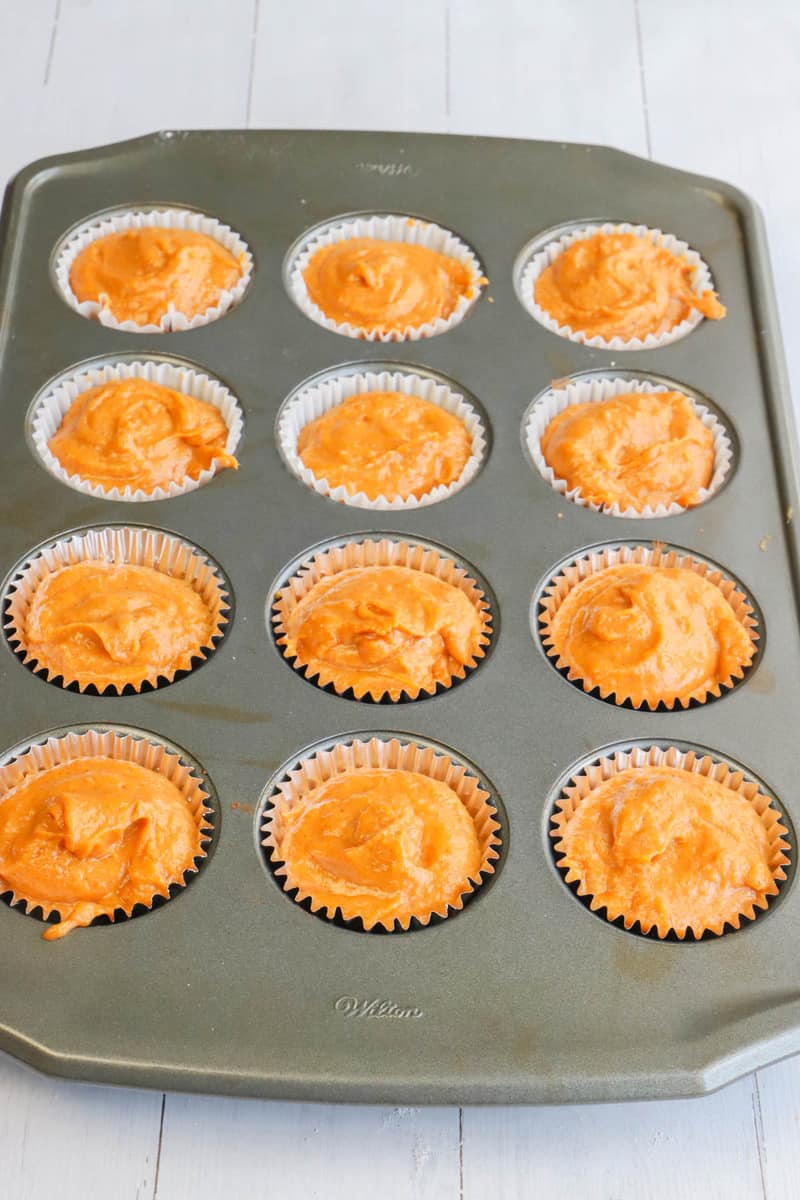 batter scooped in the muffin liners in a muffin pan