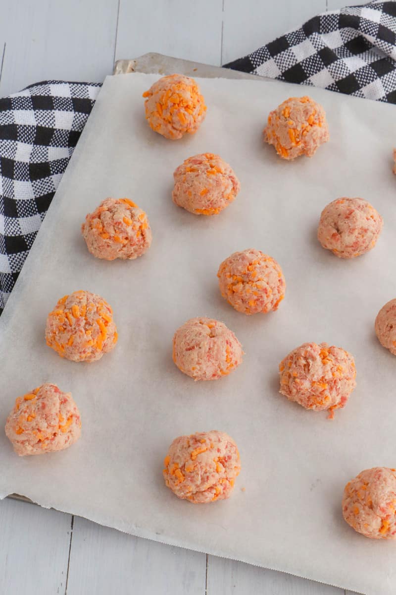 sausage balls on baking sheet with parchment paper on the baking sheet