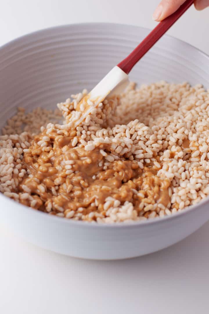 mixing up melted peanut butter with rice Krispies