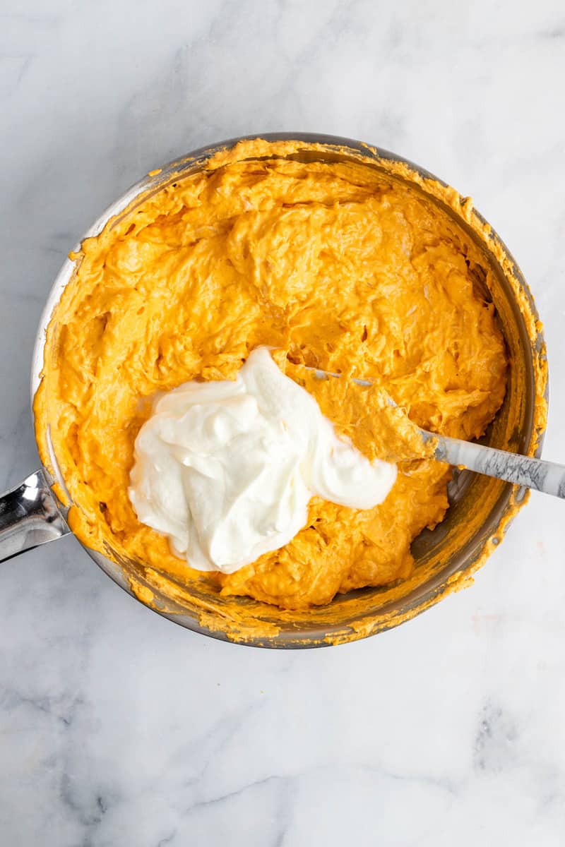 adding sour cream to the dip.