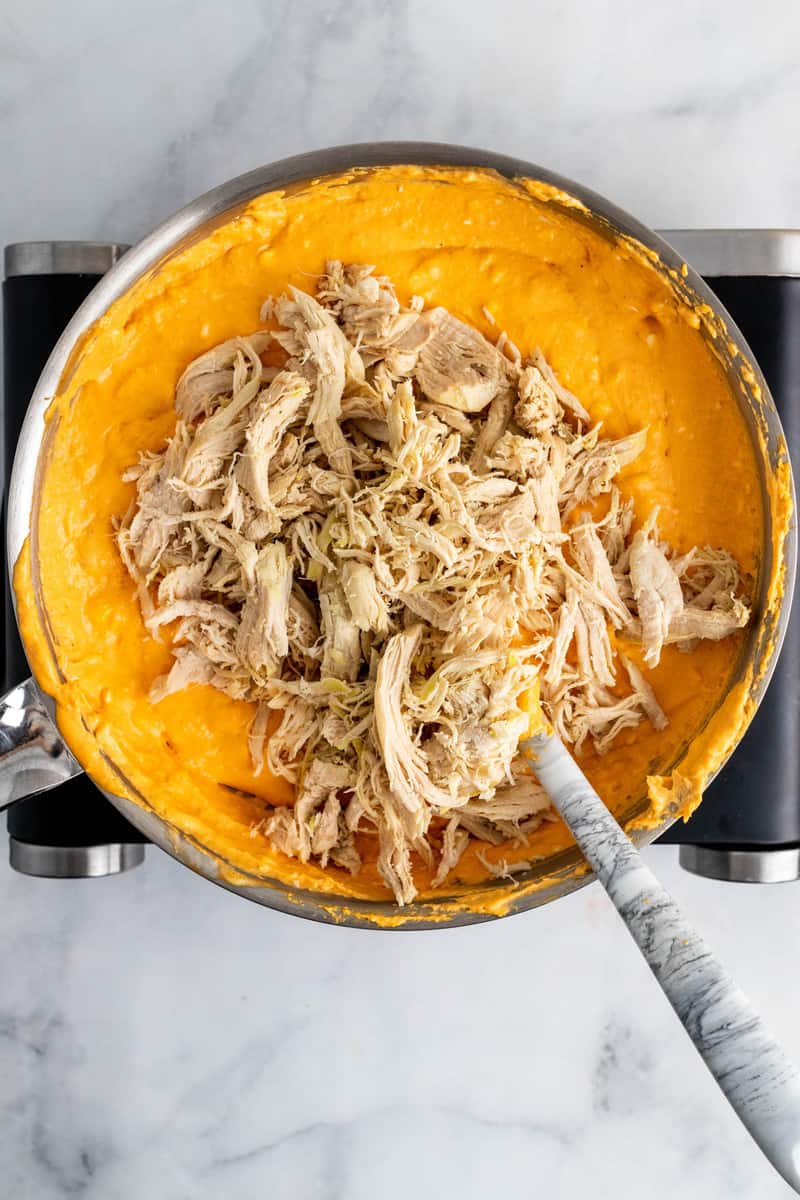 adding the shredded chicken to the dip