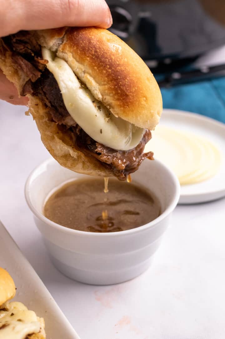 Dipping the French Dip sandwich into a cup of the au jus.