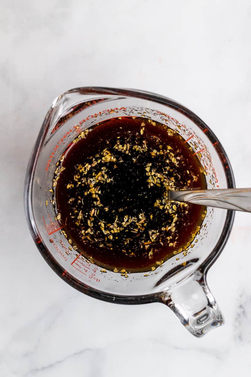 making au jus by mixing broth and spices together.