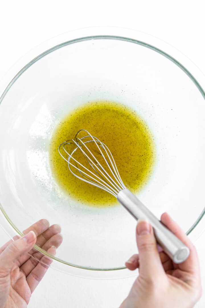 whisking together the ingredients to make the dressing