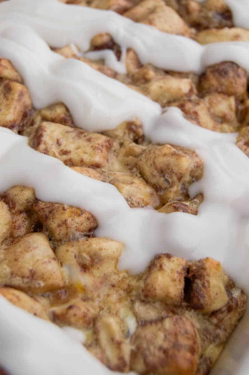 closeup of cinnamon roll casserole with icing drizzled