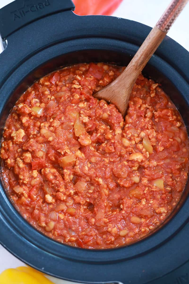 stirring the ingredients in the slow cooker.