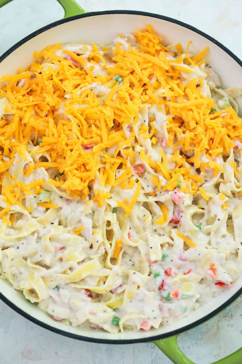 topping the casserole with cheddar cheese