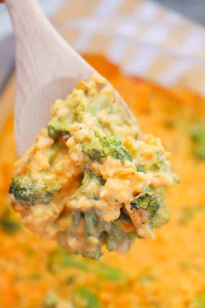 broccoli casserole being scooped out with a wooden spoon
