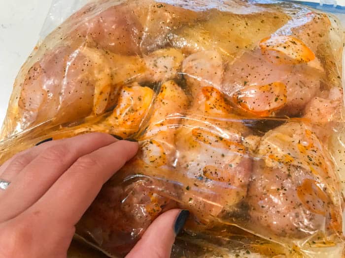 marinading the chicken in a large bag