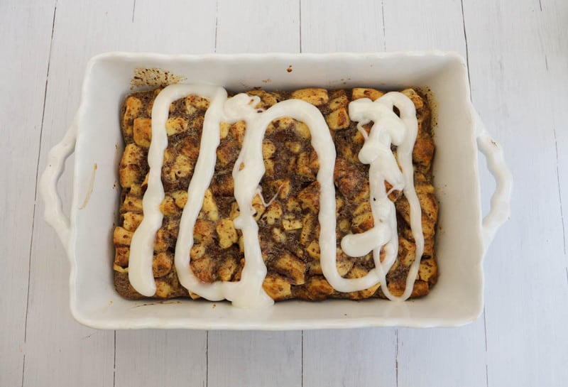 topping cinnamon roll casserole with the icing