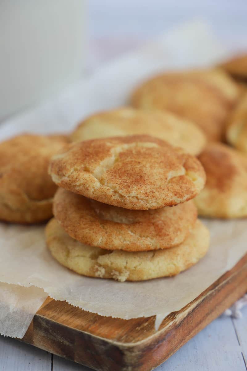 snickerdoodles stacked on top of each other on wooden tray