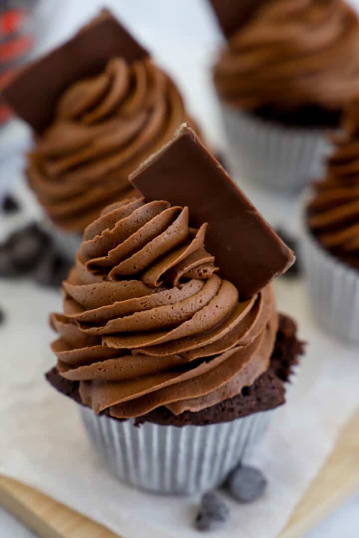 Chocolate Cupcake on wooden board with chocolate frosting and candy on top