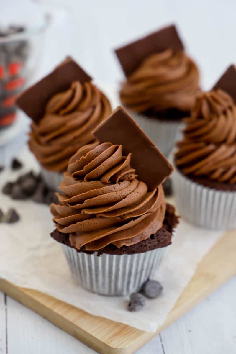 chocolate cupcakes on wooden board frosted with candy