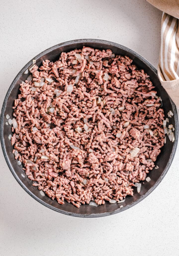 cooked ground beef and onions in skillet