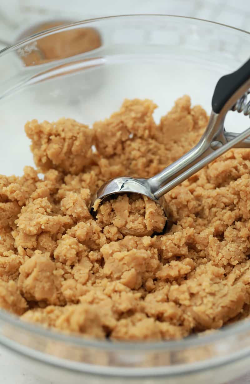 pumpkin peanut butter cookie dough being scooped into balls