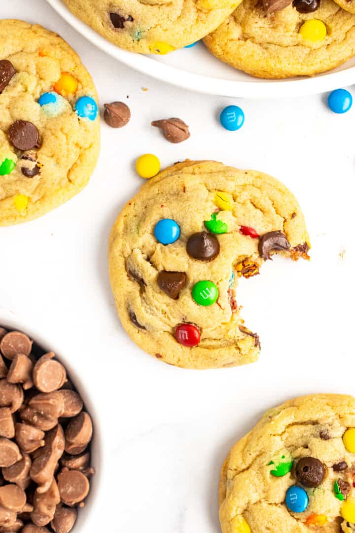 m&m cookie on white counter with a bite taken out of it