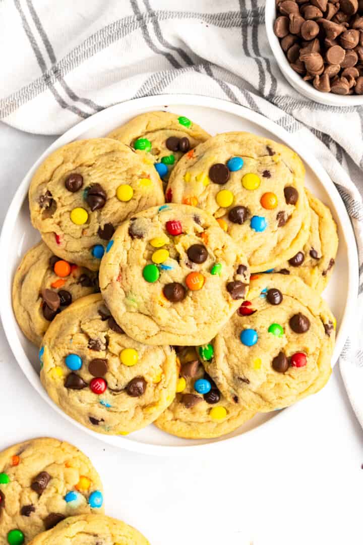 m&m cookies stacked on a white plate
