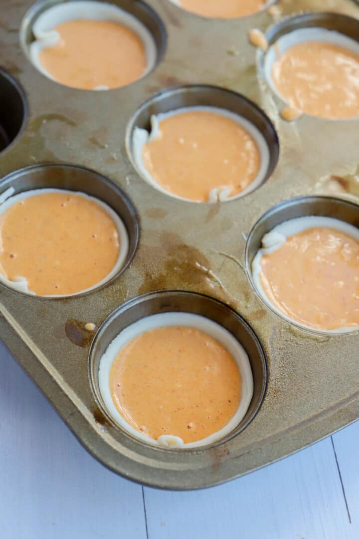 filling the muffin pan with the dough and pie filling