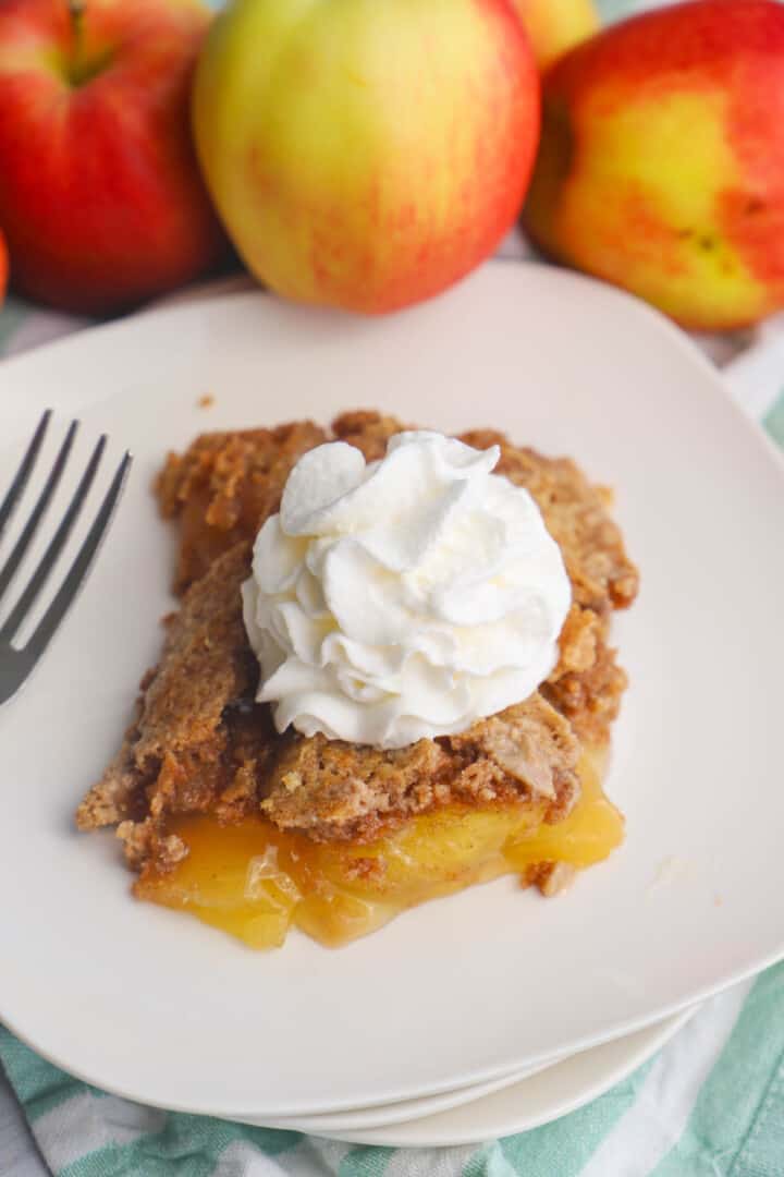 closeup of apple spice dump cake with whipped cream on top