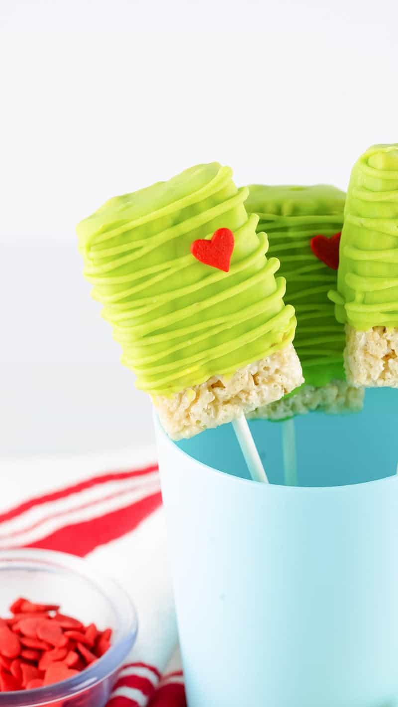 Grinch Rice Krispie Treats on sticks in a blue cup