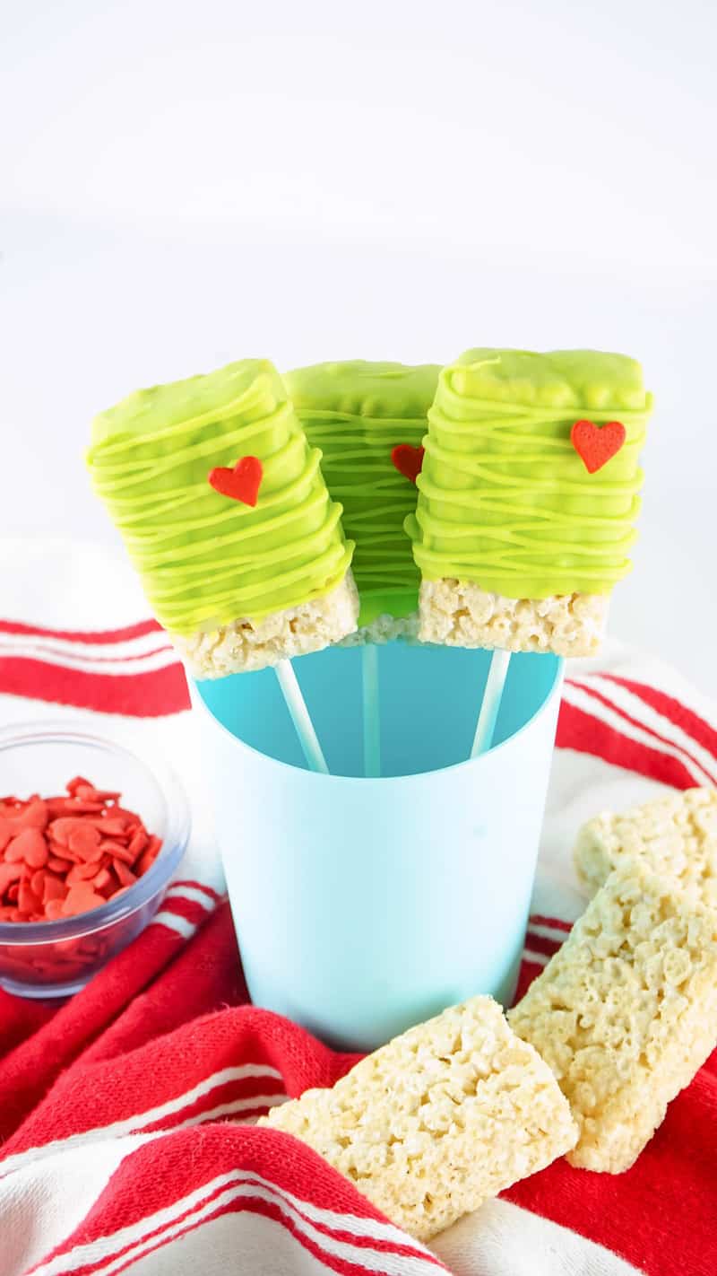 Grinch Rice Krispie Treats decorated and in a blue cup for serving