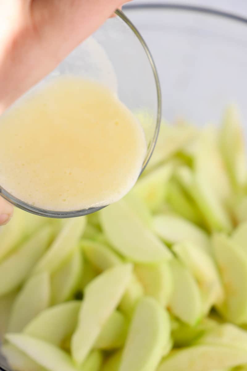 pouring melted butter over apples