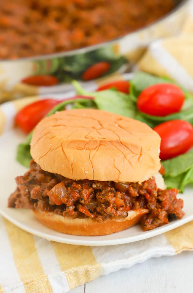 Sloppy Joe sandwich on white plate with salad